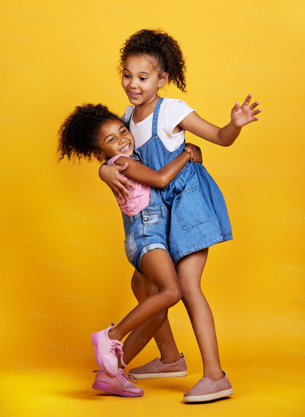Buy stock photo Children, hug and happy sisters in studio dancing with love, care and support of family on yellow background. Cute young girl kids play together for happiness, fun and positive attitude or fashion