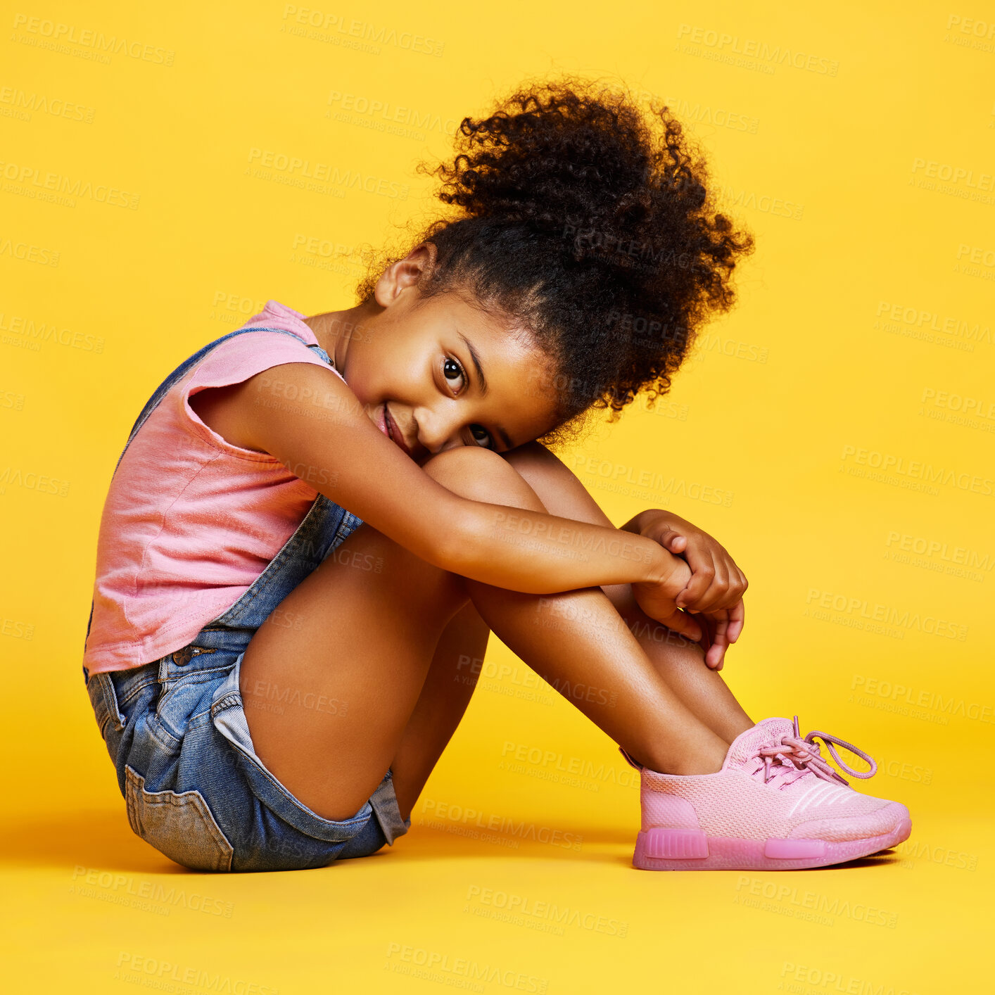 Buy stock photo Portrait, shy and girl child on studio floor for children fashion, playful and sweet against yellow background. Face, little and smile by kid with self love, pose and relax while sitting isolated