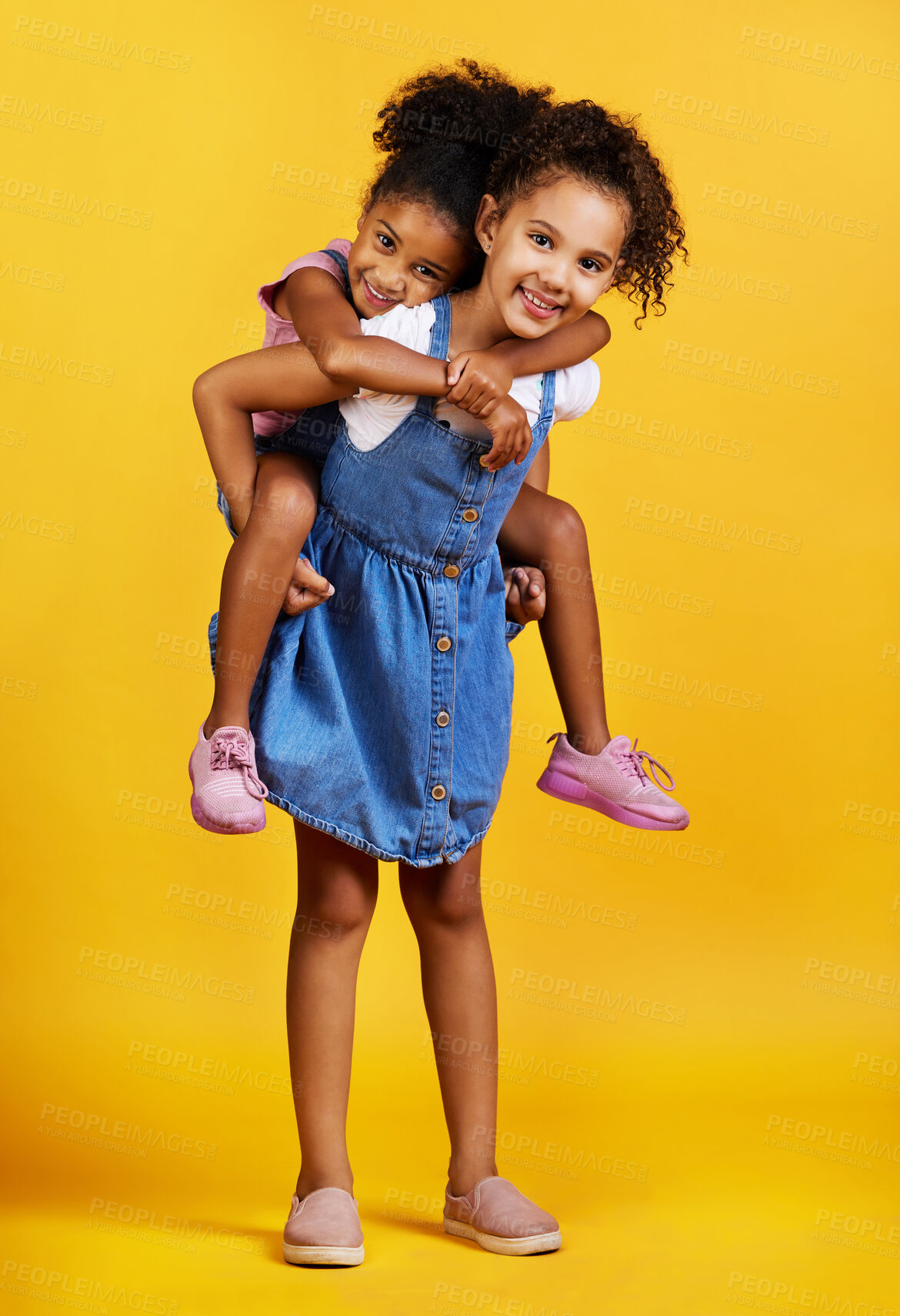 Buy stock photo Children, portrait and happy sisters for piggyback fun in studio with love of family on yellow background. Cute young girl kids or friends smile together for happiness, play and support or care