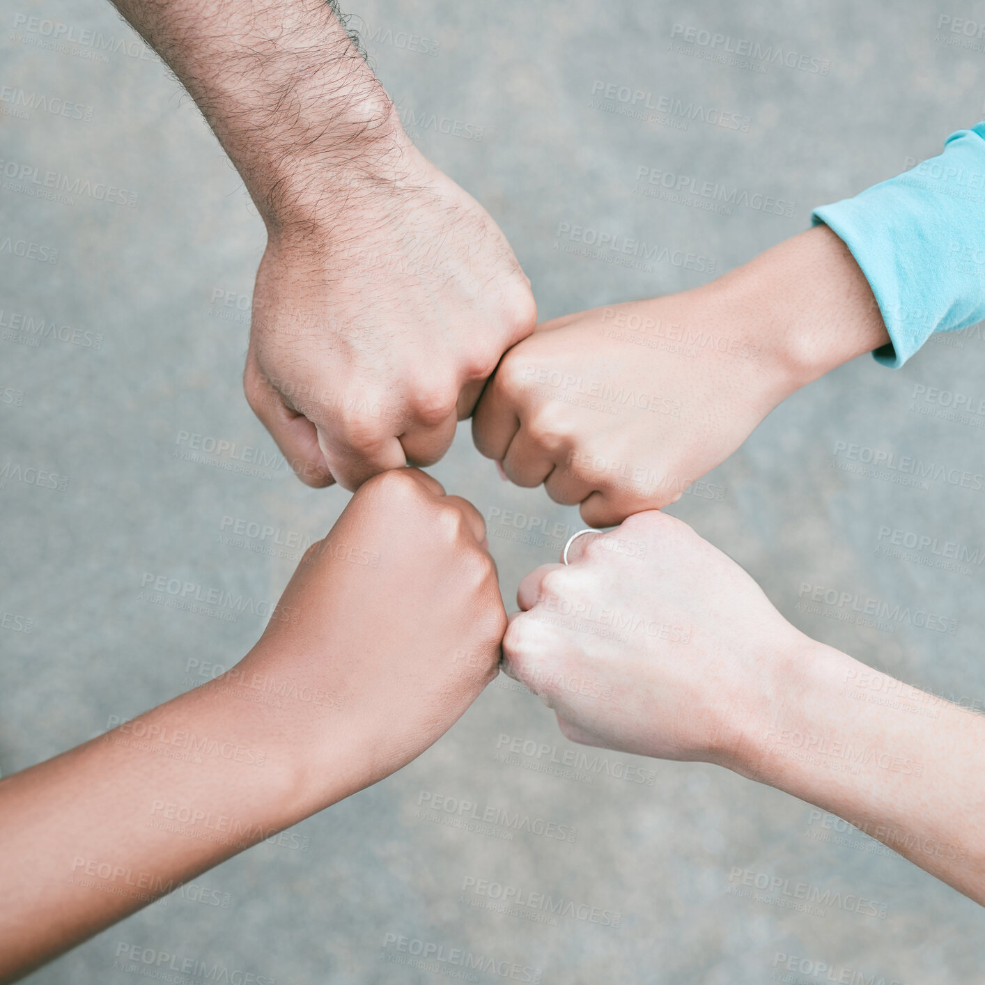 Buy stock photo Closeup of diverse group of people from above making fists in a circle to express unity, support and solidarity. Hands of multiracial community greeting with fist bump in a huddle. Society joining together for collaboration and equality
