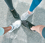 Closeup of diverse group of athletes from above wearing sports sneaker shoes and standing with feet in circle for unity, support and solidarity. Footwear of dedicated runners joining together in huddle for motivation before cardio training workout