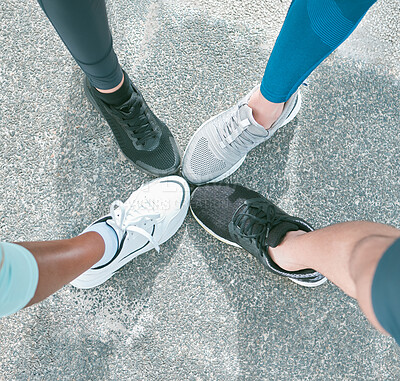 Closeup of diverse group of athletes from above wearing sports sneaker shoes and standing with feet in circle for unity, support and solidarity. Footwear of dedicated runners joining together in huddle for motivation before cardio training workout