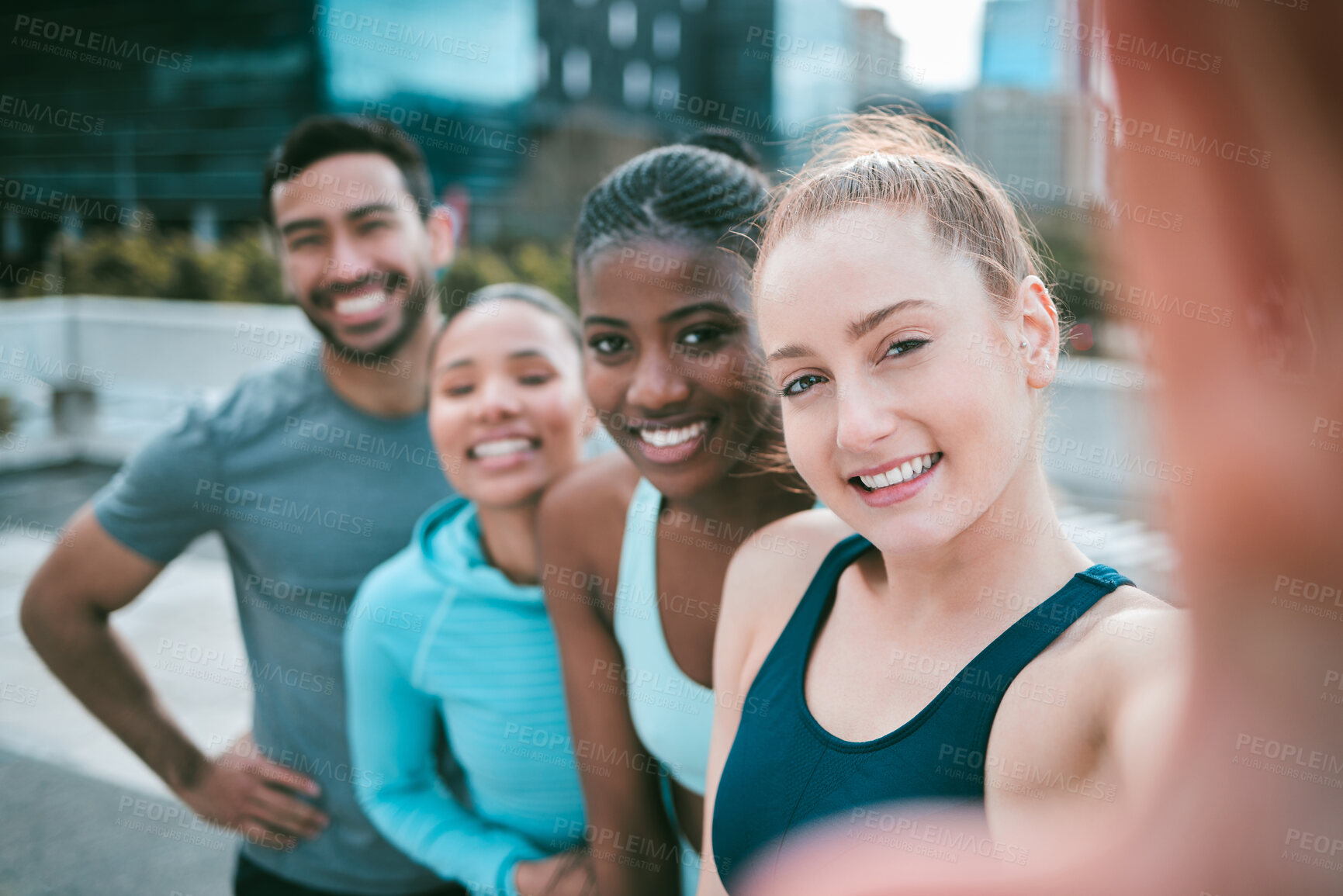 Buy stock photo Portrait of a diverse group of happy sporty people taking selfies while exercising together outside. Cheerful motivated athletes excited and ready for training workout. Supportive friends taking photos for social media