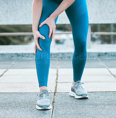 Buy stock photo Closeup of one caucasian woman holding her sore knee while exercising outdoors. Female athlete suffering with painful leg injury from fractured joint and inflamed muscles during workout. Struggling with stiff body cramps causing discomfort and strain