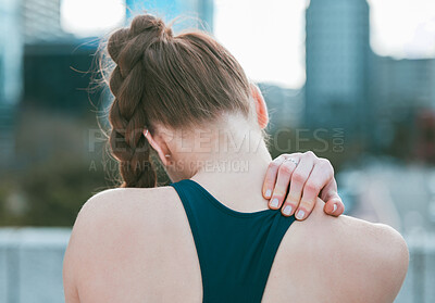Closeup of one caucasian woman from behind holding neck shoulder while exercising outdoors. Female athlete suffering with painful injury from fractured joint and inflamed muscles during workout. Struggling with stiff body cramps causing discomfort
