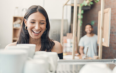 Buy stock photo One happy hispanic waitress using a coffee machine to prepare a hot beverage in a cafe. Happy barista making a warm drink to serve customers in a coffeeshop