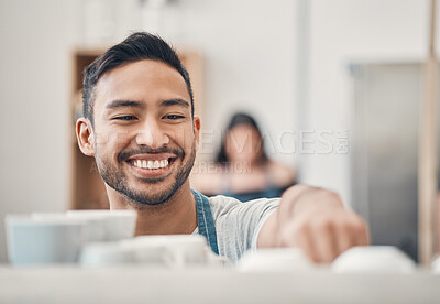 Buy stock photo One happy hispanic waiter using a coffee machine to prepare a hot beverage in a cafe. Happy barista making a warm drink to serve customers in a coffeeshop