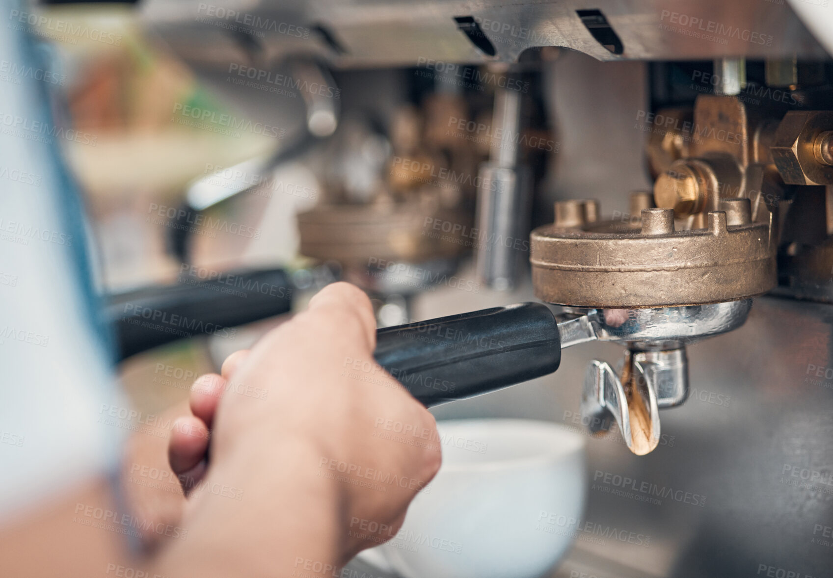 Buy stock photo Closeup of a barista using a portafilter while preparing ground coffee to make a shot of espresso for cappuccino or latte in a cafe. Hands of waiter using a brewing machine to make a warm beverage in a coffeeshop
