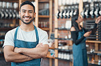 Portrait of one happy young hispanic waiter standing with his arms crossed in a store or cafe. Friendly man and coffeeshop owner managing a successful restaurant startup
