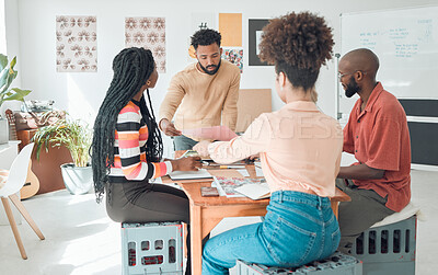 Buy stock photo Group of diverse businesspeople having a meeting in a modern office at work. Young hispanic businessman looking at an idea on paper in a boardroom with colleagues. Businesspeople planning together
