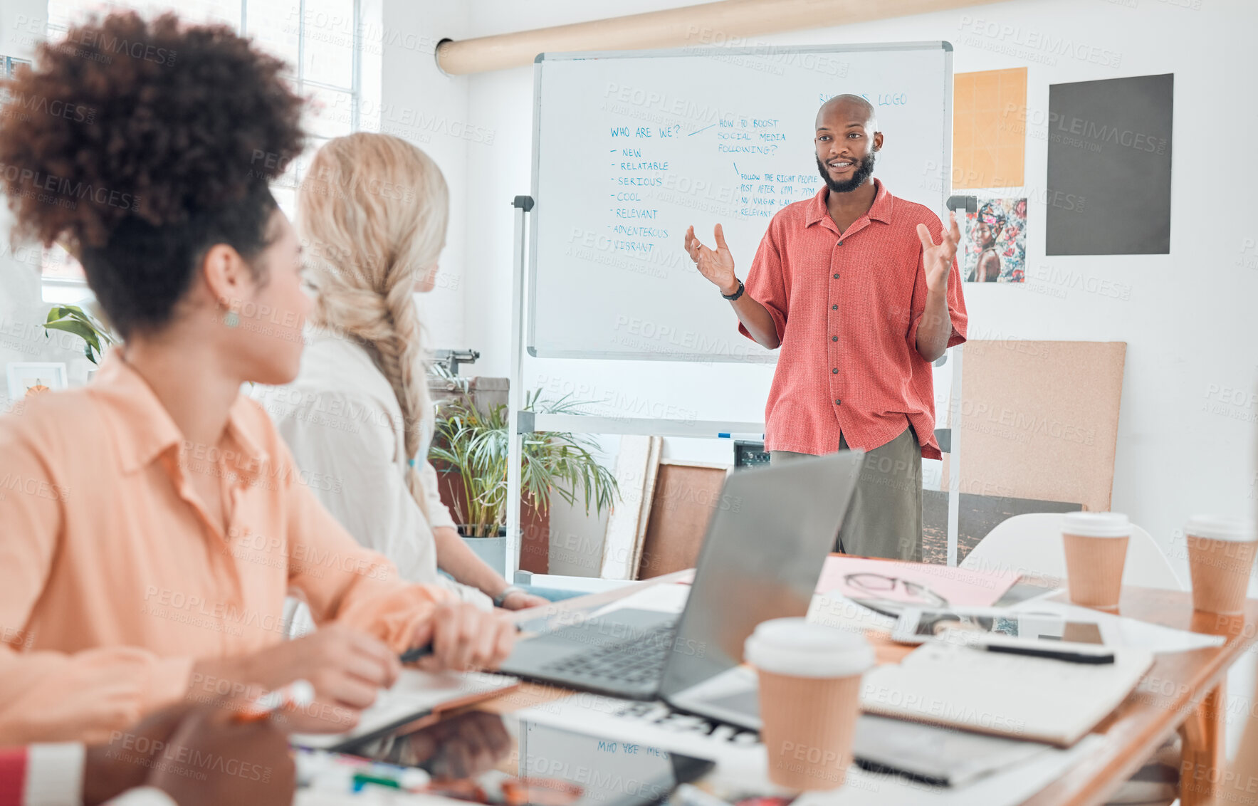 Buy stock photo Group of diverse businesspeople having a meeting in a modern office at work. Young african american businessman talking while doing a presentation of an idea on a whiteboard in a boardroom with colleagues. Businesspeople planning together