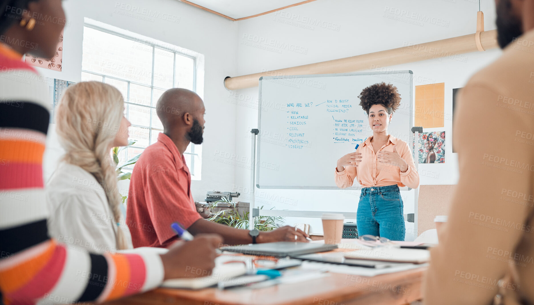 Buy stock photo Group of diverse businesspeople having a meeting in a modern office at work. Young hispanic businesswoman with a curly afro talking while doing a presentation of an idea on a whiteboard in a boardroom with colleagues. Businesspeople planning together