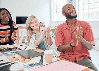 Buy stock photo Group of happy diverse businesspeople having a meeting in a modern office at work. Joyful colleagues clapping hands for a coworker while sitting at a table. Creative businesspeople planning together