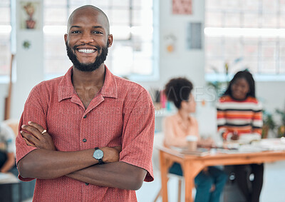 Young happy african american businessman standing with his arms crossed while in an office. Confident male manager smiling and standing at work