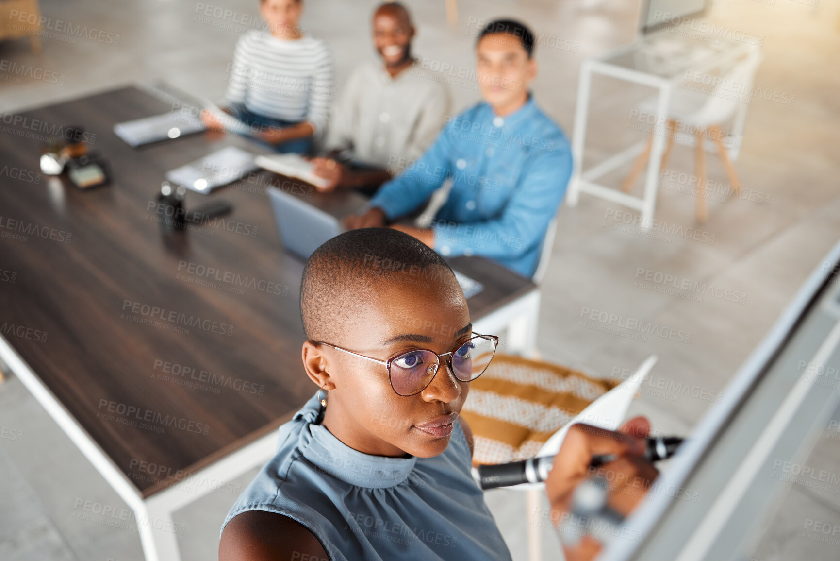Buy stock photo Group of diverse businesspeople having a meeting in an office at work. Young african american businesswoman writing an idea on a whiteboard in a boardroom with colleagues. Businesspeople planning together
