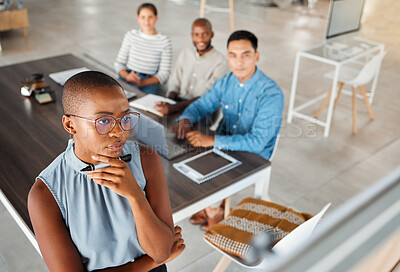 Group of diverse businesspeople having a meeting in an office at work. Young focused african american businesswoman thinking of an idea on a whiteboard in a boardroom with colleagues. Businesspeople planning together