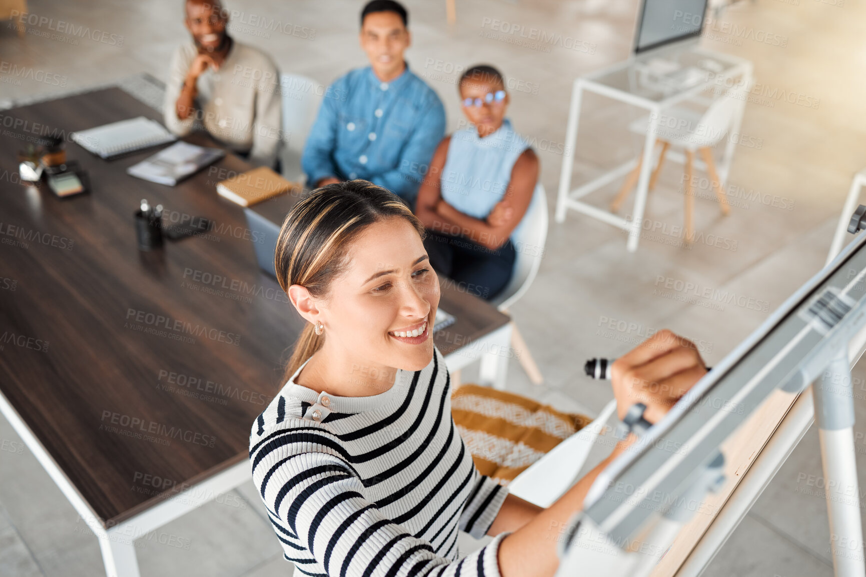 Buy stock photo Group of diverse businesspeople having a meeting in an office at work. Young happy mixed race businesswoman smiling while writing an idea on a whiteboard in a boardroom with colleagues. Businesspeople planning together