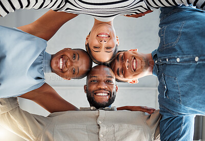 Portrait of a group of young diverse businesspeople smiling and huddling in support at work. Cheerful colleagues standing united to motivate each other. Faces of happy coworkers in an office