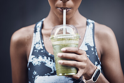 Fitness woman drinking a healthy green smoothie juice for a detox weight  loss cleanse. Happy sporty