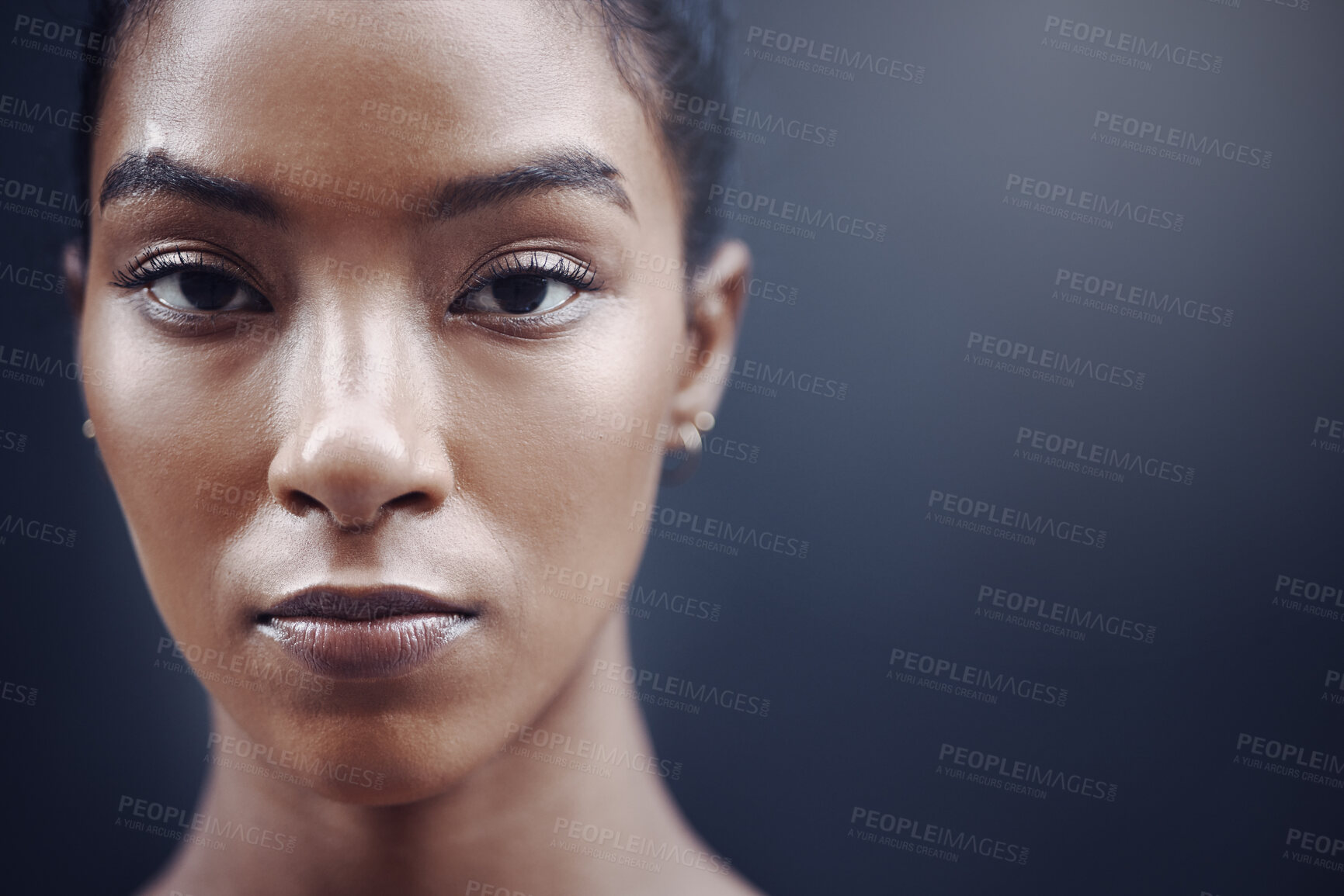 Buy stock photo Closeup portrait of one focused mixed race woman with copyspace against a grey background. Face of determined and motivated female athlete staring and watching ahead in front