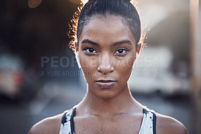 Buy stock photo Closeup portrait of one focused mixed race woman sweating after an intense workout or run in the city. Face of determined and motivated female athlete wearing earphones and taking a break from exercise outdoors