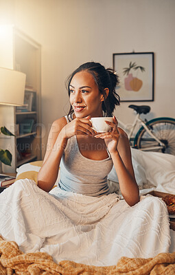 Buy stock photo A beautiful young Hispanic woman enjoying a warm cup of coffee for breakfast. One mixed race female drinking tea while sitting in bed and daydreaming