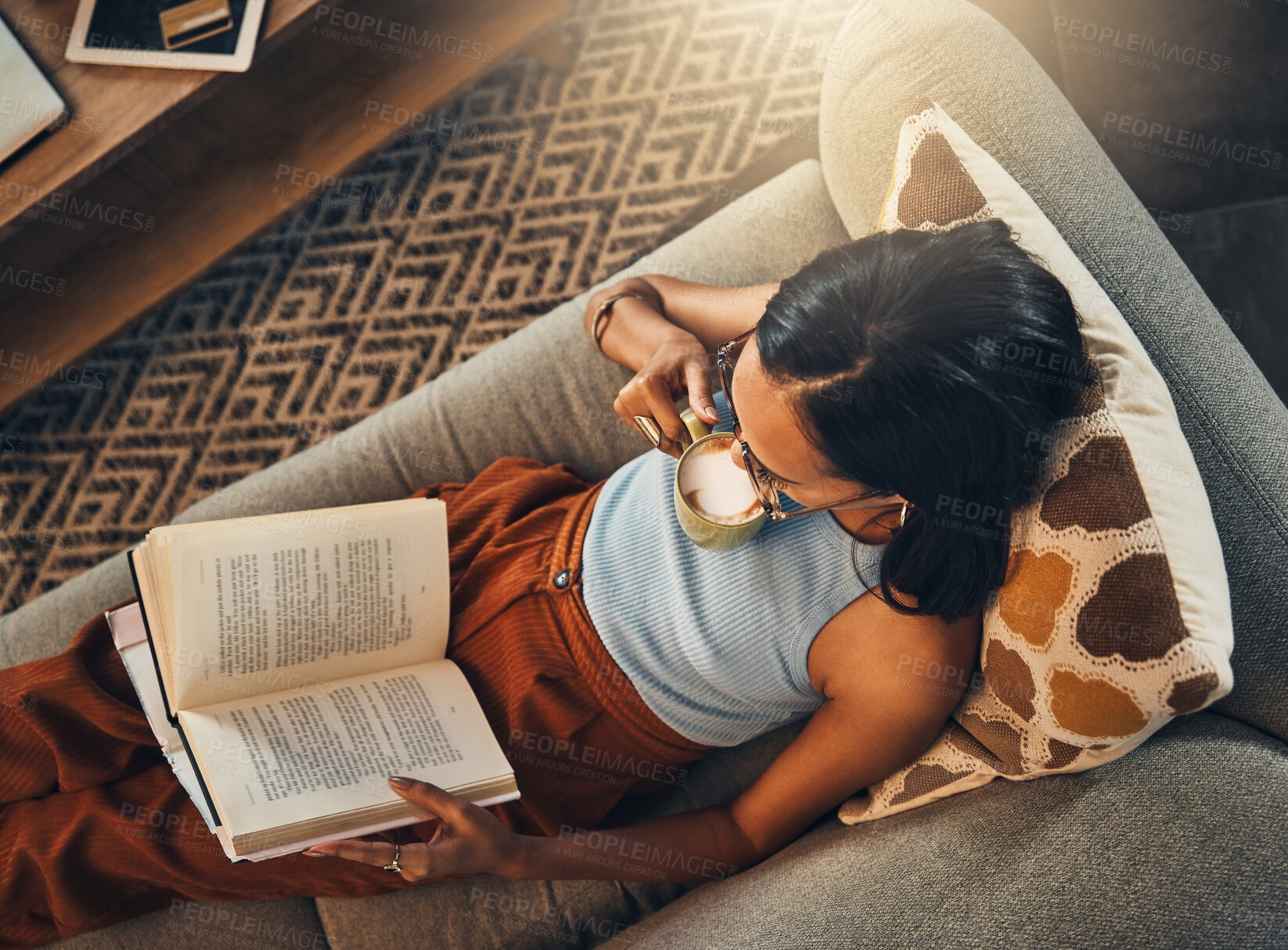 Buy stock photo Top view of woman sofa, reading book with coffee at house and break on the weekend with poetry story at home. Female person relax, calm on living room couch and read for knowledge with hot drink