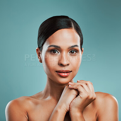 Buy stock photo Portrait of a young beautiful mixed race woman with smooth soft skin posing against a green studio background. Attractive Hispanic female with stylish makeup posing in studio