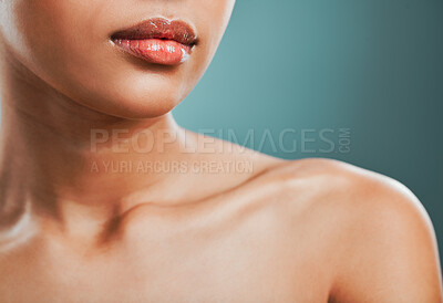 Closeup view of a mixed race woman posing against a green background. Female showing her healthy smooth soft skin in a studio