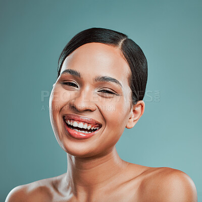 A young beautiful mixed race woman with smooth soft skin posing and smiling against a green studio background. Attractive Hispanic female with stylish makeup posing in studio