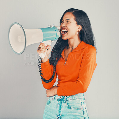 Buy stock photo Mixed race woman isolated against grey studio background with copyspace and using megaphone. Young hispanic standing alone and protesting and promoting empowerment. Model showing support and arguing