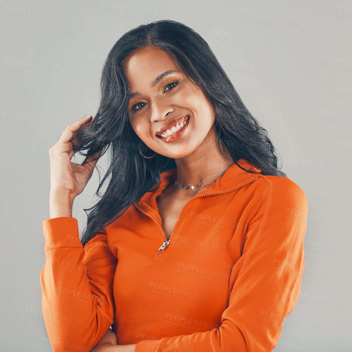 Buy stock photo Portrait of mixed race woman isolated against grey studio background with copyspace and feeling confident. Beautiful young smiling hispanic standing alone. One happy model posing while touching hair