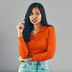 Mixed race woman isolated against grey background in studio with copyspace and looking annoyed. Irritated young hispanic standing alone and making disgusted facial expression. Being mean and a bully