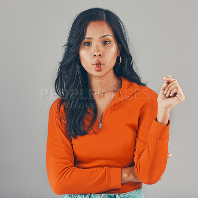 Buy stock photo Portrait of mixed race woman isolated against grey studio background with copyspace and pouting. Beautiful young hispanic standing alone and making silly and goofy facial expression. One model posing