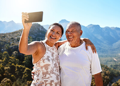 Buy stock photo Happy mature couple taking a selfie or doing video call while standing outdoors in sportswear. Active senior couple enjoying healthy lifestyle