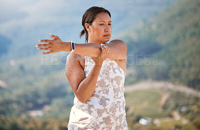 Buy stock photo Mature mixed race woman stretching her arms while exercising in nature. Woman doing yoga outdoors and living a healthy and active lifestyle