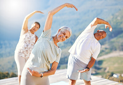 Buy stock photo Group of senior people stretching with their hands over heads outdoors. Happy mature people doing yoga exercise in nature on a sunny day. Yoga class with men and women stretching together