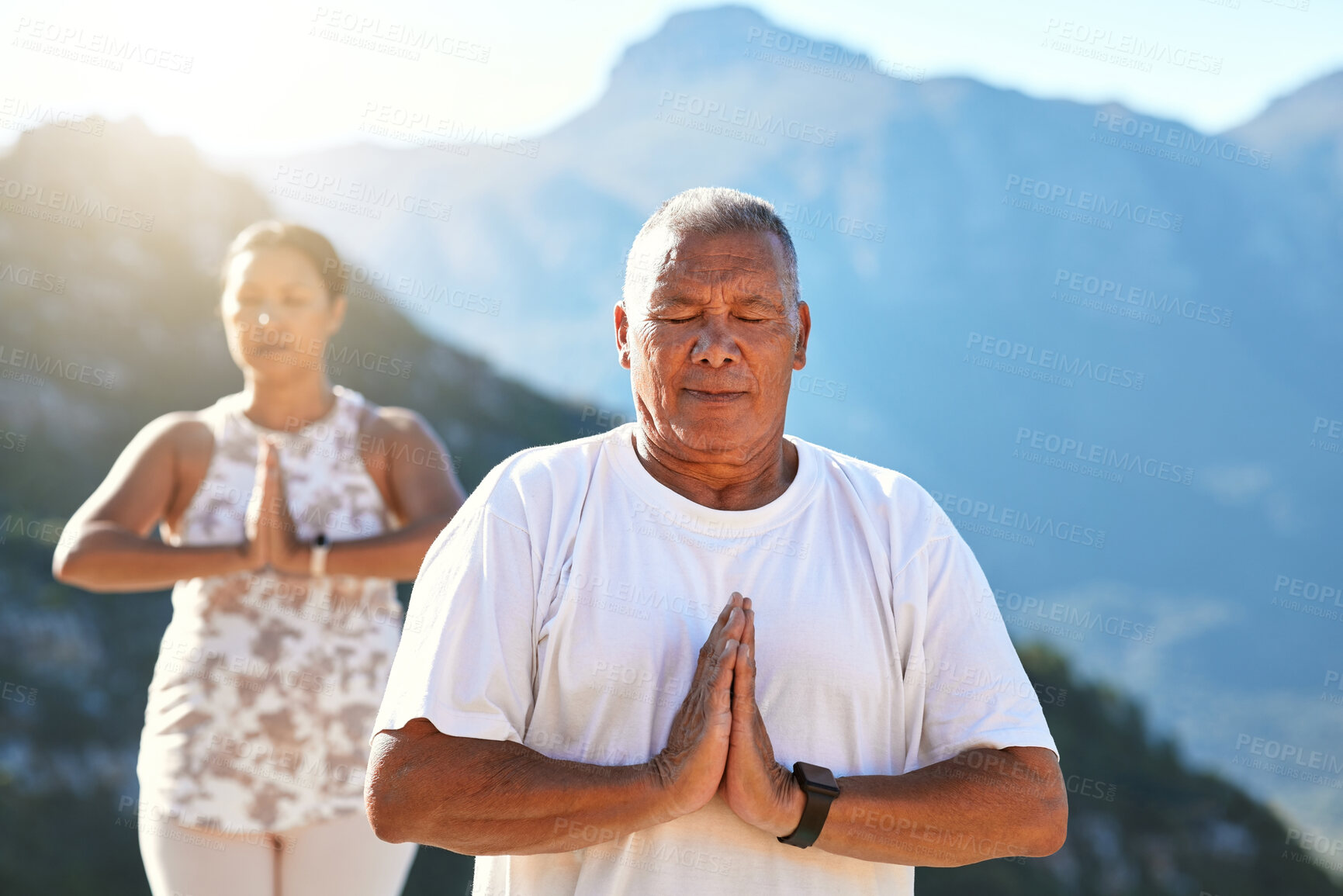 Buy stock photo Senior couple meditating with joined hands and closed eyes breathing deeply. Mature couple doing yoga in nature living a healthy active lifestyle in retirement