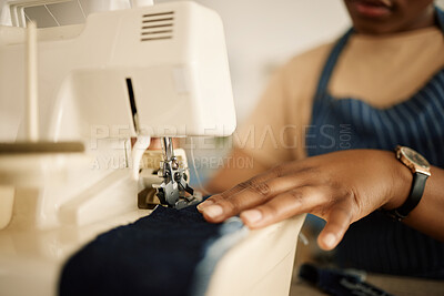 Buy stock photo Closeup of hands of tailor using sewing machine. Fashion designer feeding denim through sewing machine. Hand of a seamstress stitching a piece of material. Creative businesswoman working in a studio