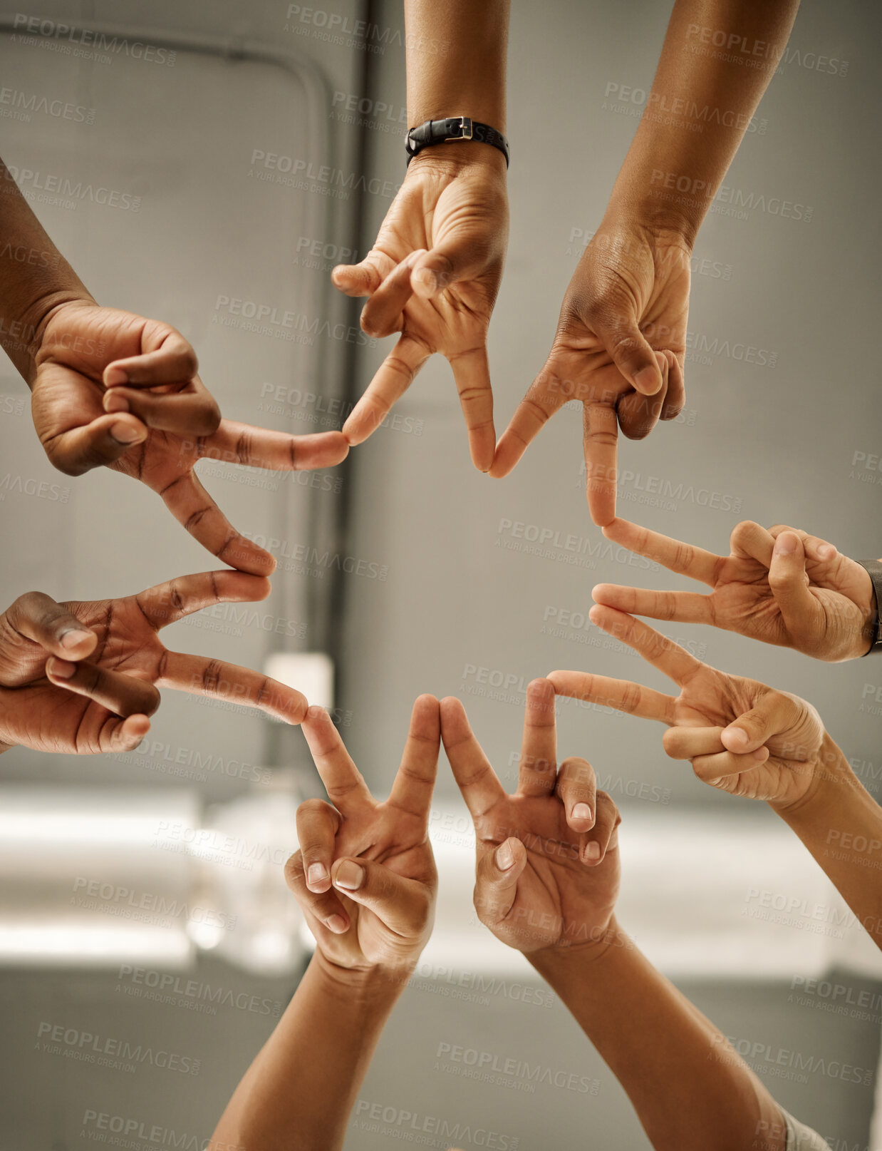 Buy stock photo Closeup of hands of coworkers making peace signs in a star shape. Colleagues forming peace signs from below. Group of businesspeople collaborating together. Businesspeople joined together in unity