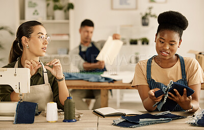 Buy stock photo Diverse designers talking about fabric sample. Seamstress colleagues talking about denim material.Two fashion designers talking about textile samples. Creative businesswomen collaborate