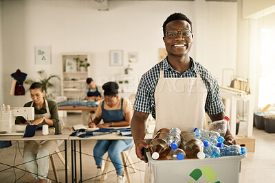 African american designer holding a recycling bin. Businessman holding a bucket of recycled plastic bottles. Young tailor holding a recycling bin. Smiling designer recycling plastic bottles