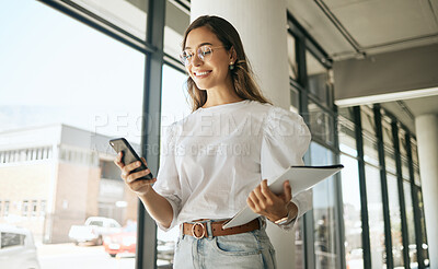 Buy stock photo Happy business woman texting on smartphone holding file and walking in modern office. Smiling female entrepreneur using mobile app or browsing social media