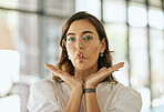 Funny business woman with glasses posing with her hands under her face and making fish face grimace with pout lips in an office. Playful hispanic female entrepreneur fooling and and being silly