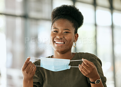 Buy stock photo African american business woman putting on protective face mask in the office for safety and protection during COVID-19. Happy female entrepreneur getting ready to work
