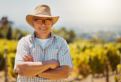 One smiling senior mixed race confident farmer standing with his arms crossed on his vineyard with copyspace. Hispanic elderly man with his arms folded on a wine farm and wearing sunglasses and a hat