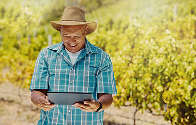 Buy stock photo Smiling senior mixed race farmer using a digital tablet on his vineyard. Elderly hispanic man standing alone and using technology on a wine farm in summer. Happy farmer with his crops and agriculture