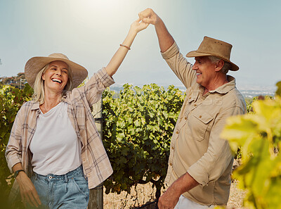 Smiling senior couple dancing together and feeling playful on vineyard. Caucasian husband and wife standing together and enjoying a day on a farm after wine tasting weekend. Man and woman having fun