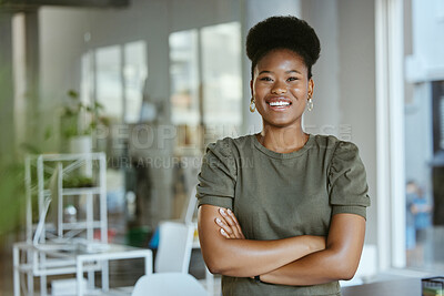Buy stock photo Young happy african american businesswoman standing with her arms crossed alone at work. One cheerful black female boss with an afro smiling while standing in an office