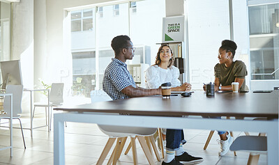 Buy stock photo Three young happy businesspeople having a meeting while sitting at a table at work. Business professionals talking and planning in an office together